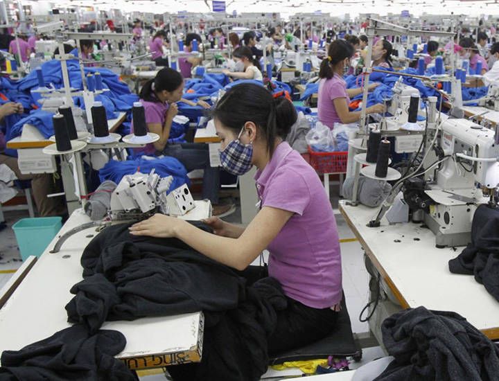 Skilled factory worker handling fabric manufacturing process in Indonesia textile plant